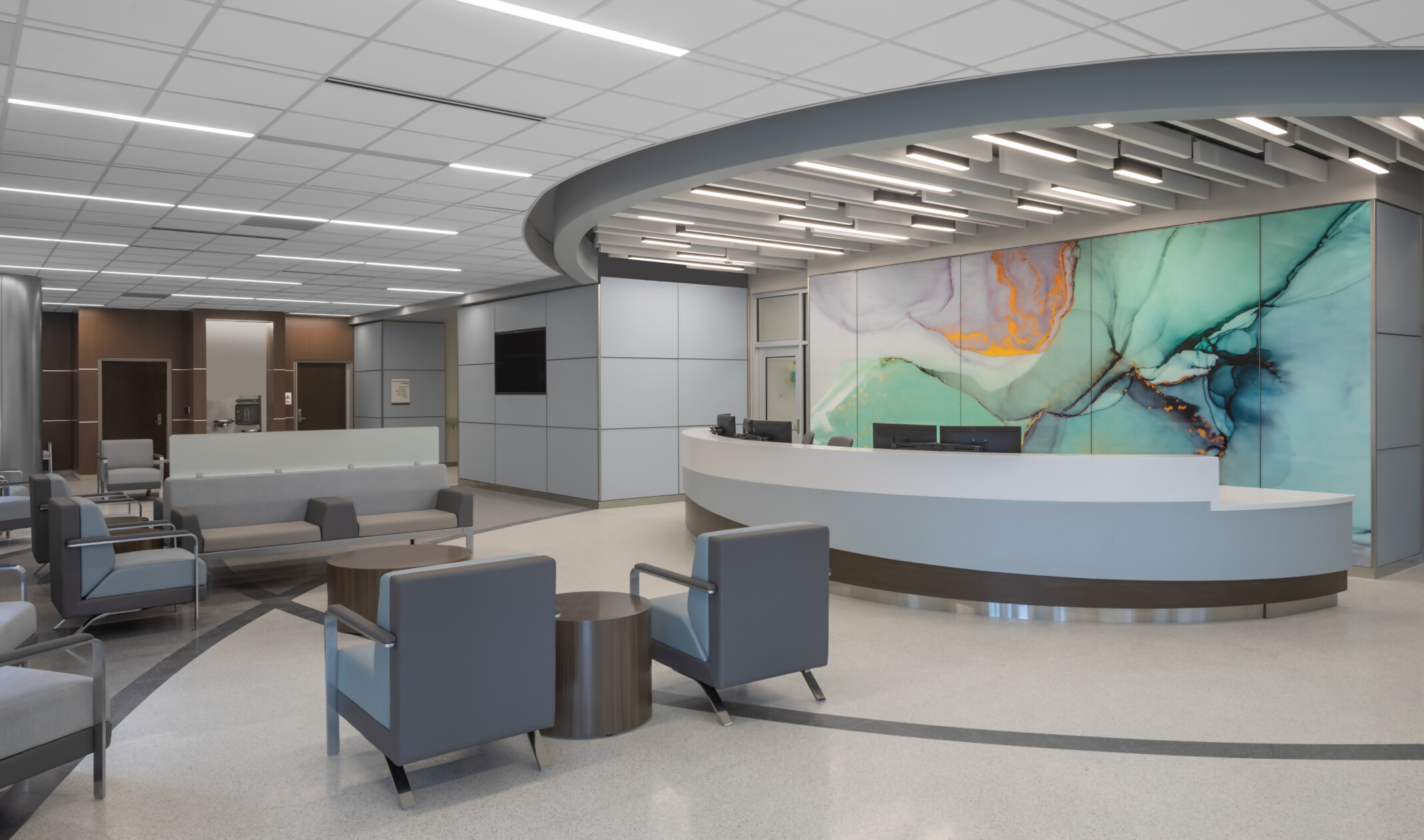 Waiting area lobby with long rounded reception desk in front of marbled wall mural in green with gold and purple accents