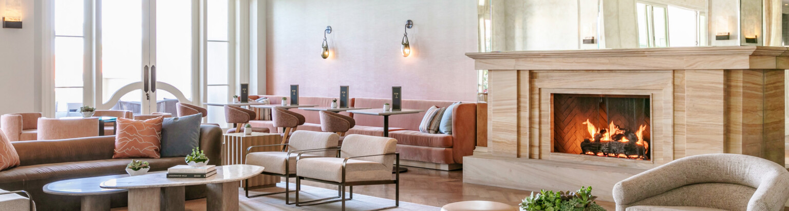 luxury interior of a hotel lobby, eating space; feature fireplace in the center of the room