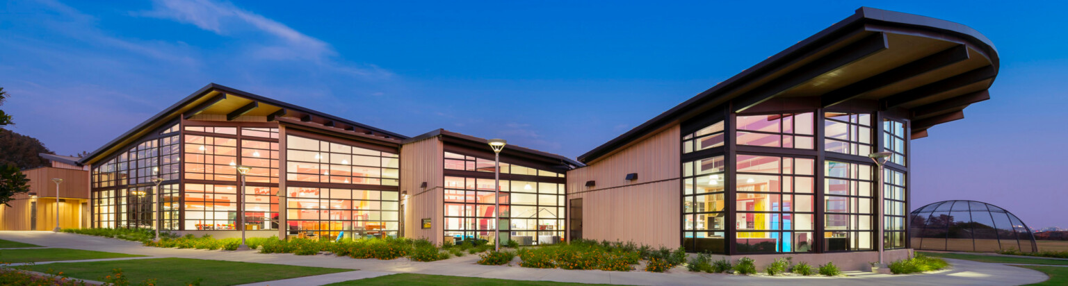 exterior of Del Mar Heights School at night, architecture inspired by California Coastal Architecture; indoor outdoor learning space with large openable windows