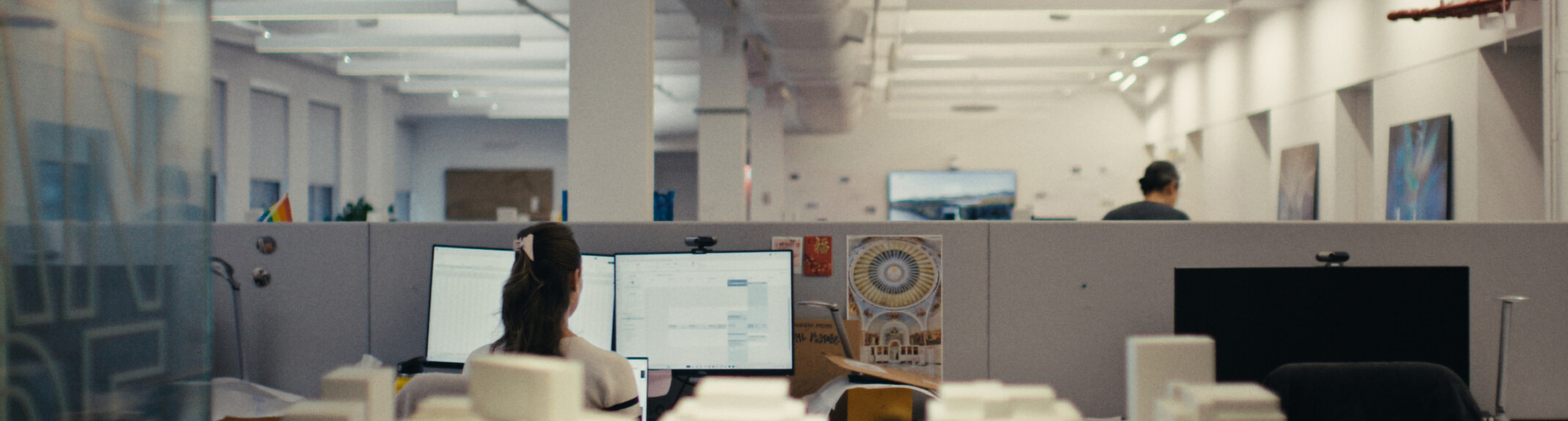 Modern office cubicle with building models in foreground; DLR Group new york office