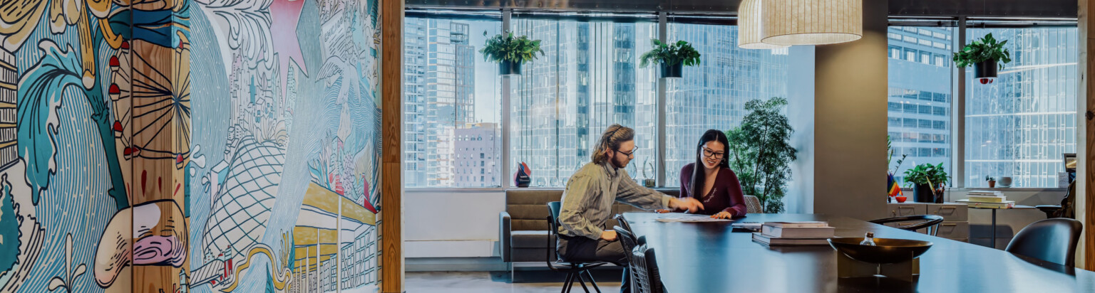 modern office large collaboration table with left hand mural wall and background windows with buildingscape; DLR Group Chicago office