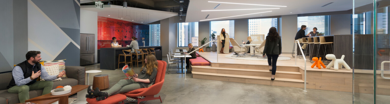 Communal modern office space with collaboration zones and communal kitchen in the background; DLR Group Denver office