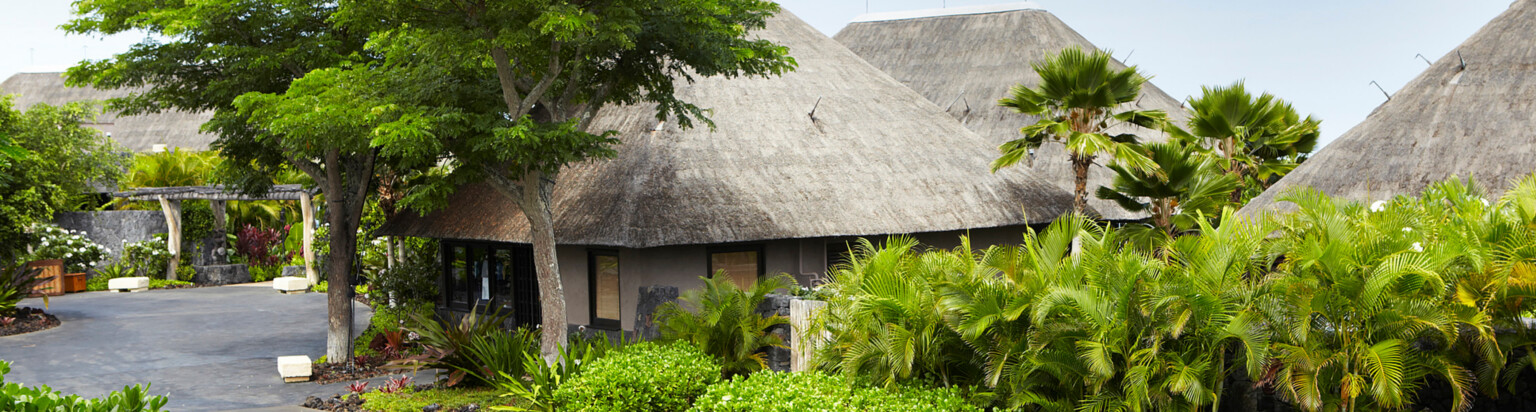 hawaiian resort villa with rustic roofing surrounded by lush greenery