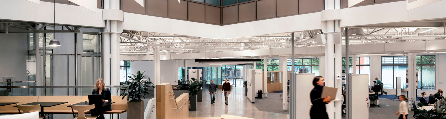 modern office walkway zone with seating and desking to the left and right of the major walkway; DLR Group Portland office