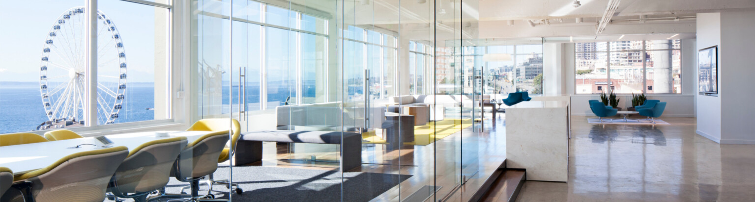 modern bright, airy office with multiple collaboration zones overlooking the water and a ferris wheel; DLR Group seattle office