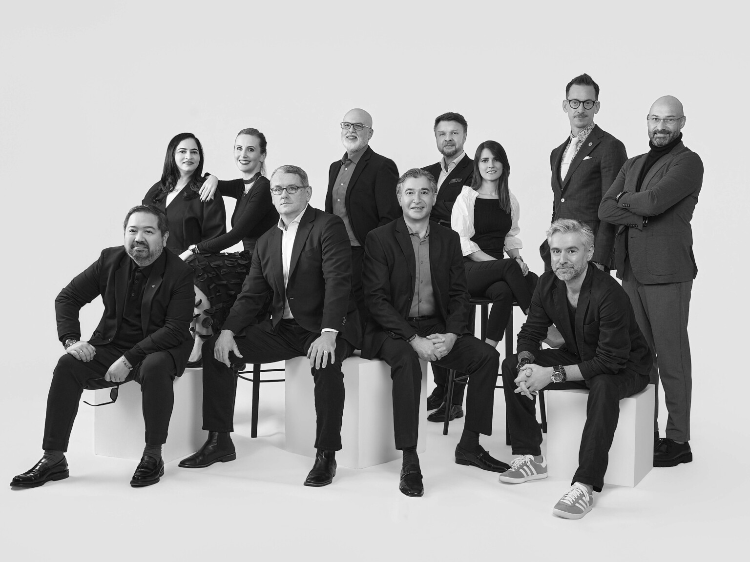 black and white photo of a group of people; variously posed to signal modern professionalism