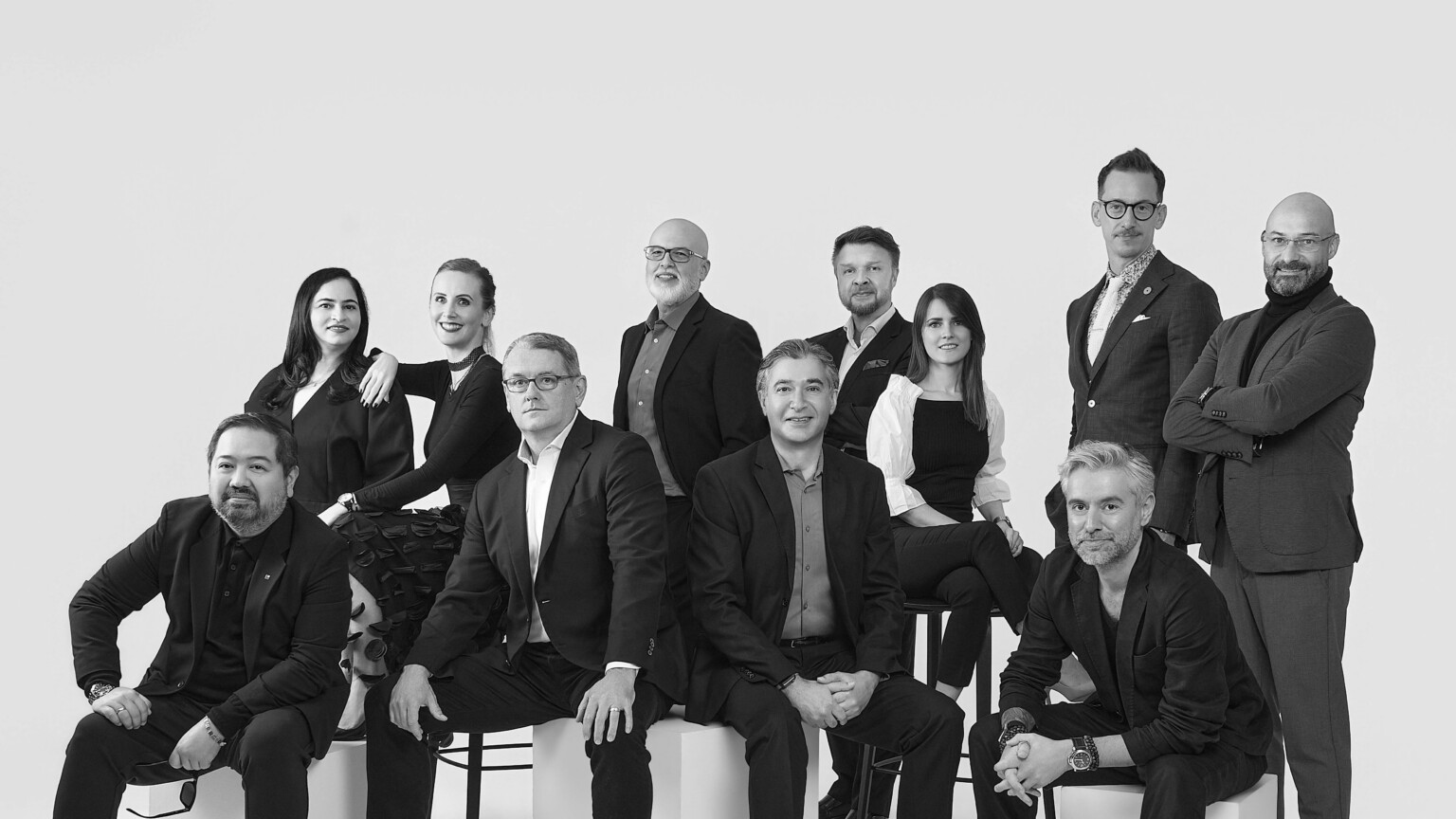 black and white photo of a group of people; variously posed to signal modern professionalism