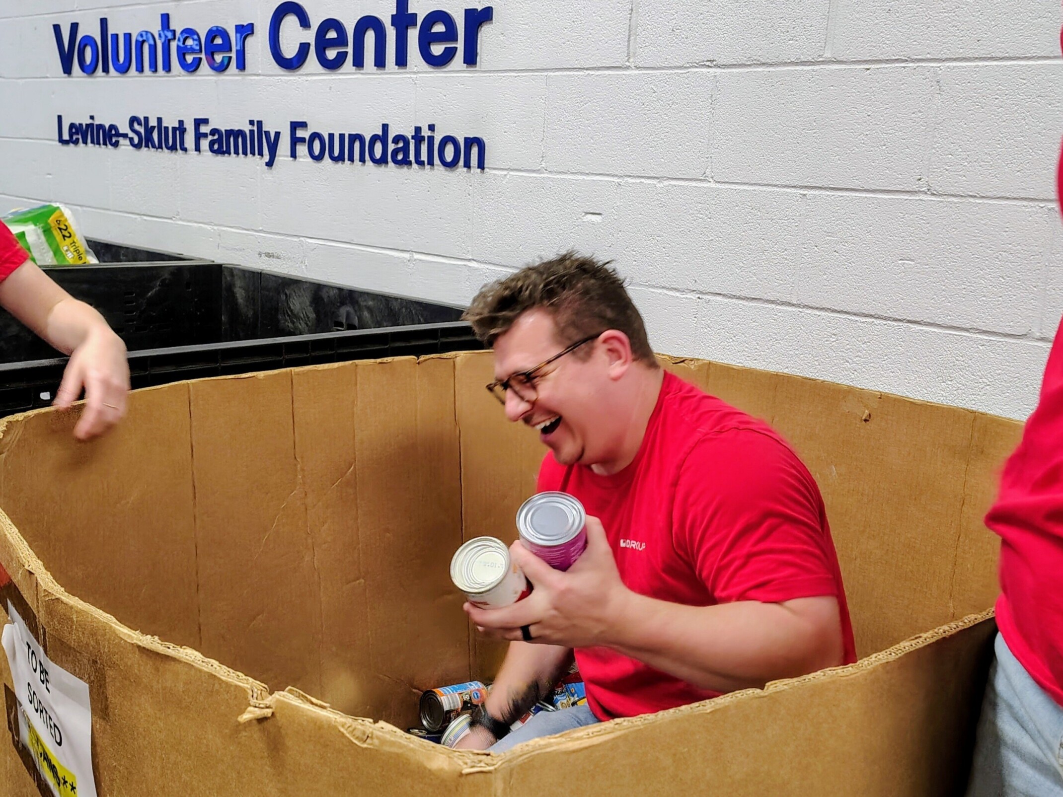 DLR Group employee packing cans in a cardboard box