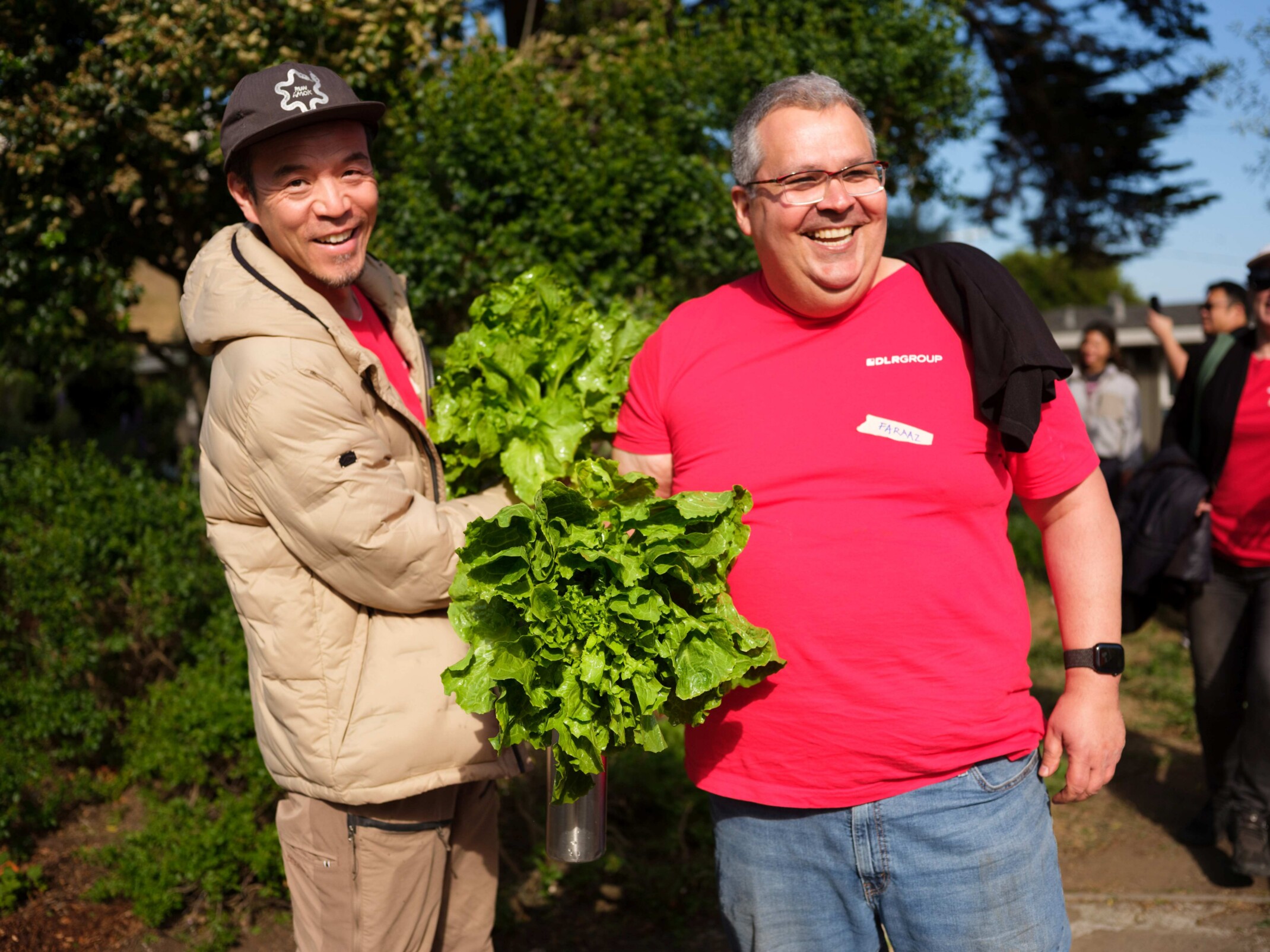 Two DLR Group employees standing holding leafy green