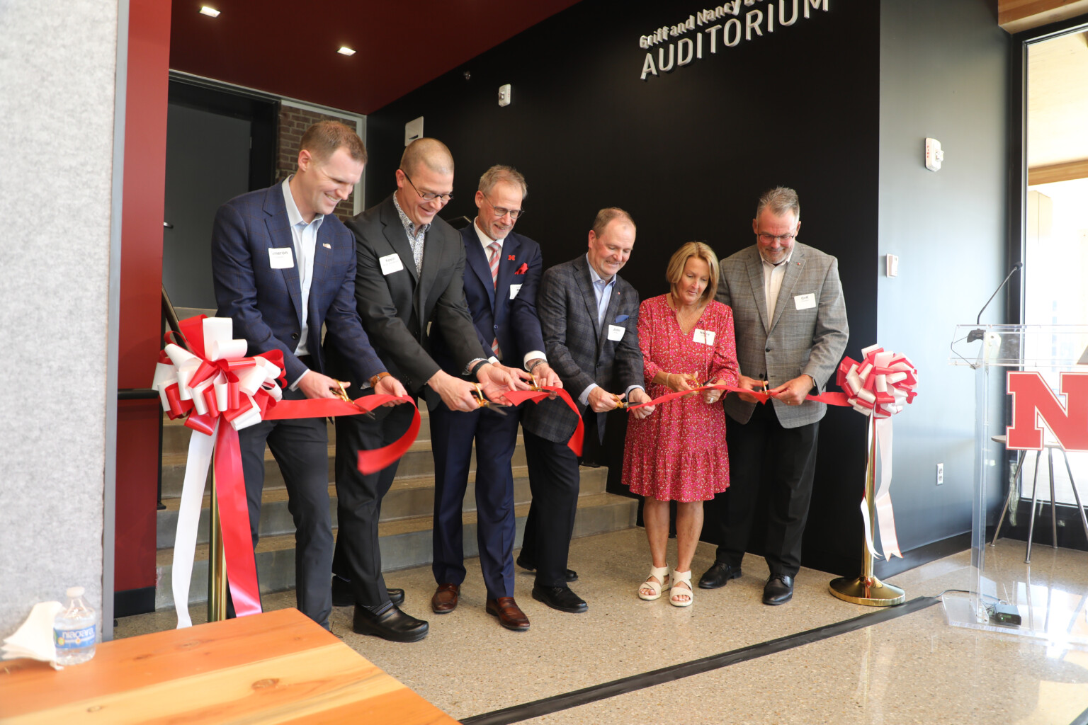 DLR Group ceremony with people cutting ribbon to celebrate lecture hall dedication to Griff and Nancy Davenport