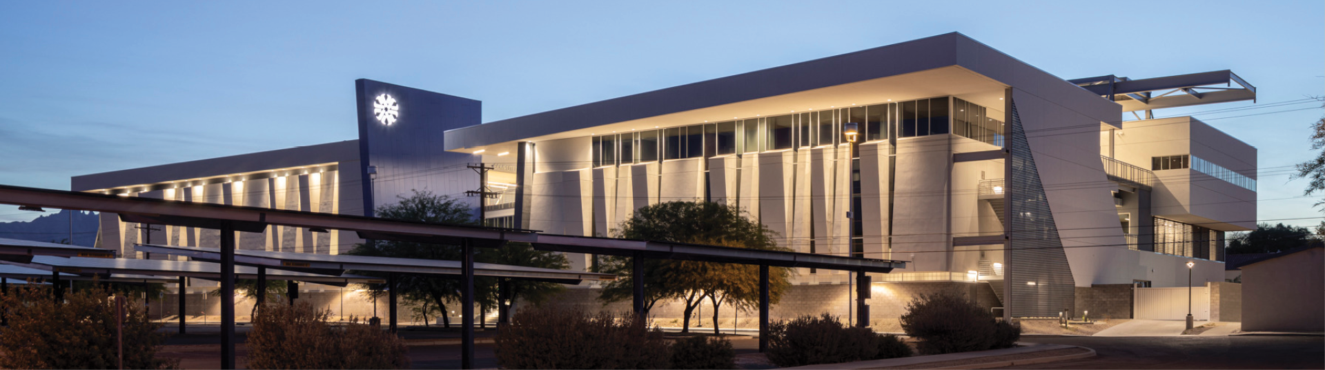 night view of pima community college, vertical lights illuminate the perforated facade