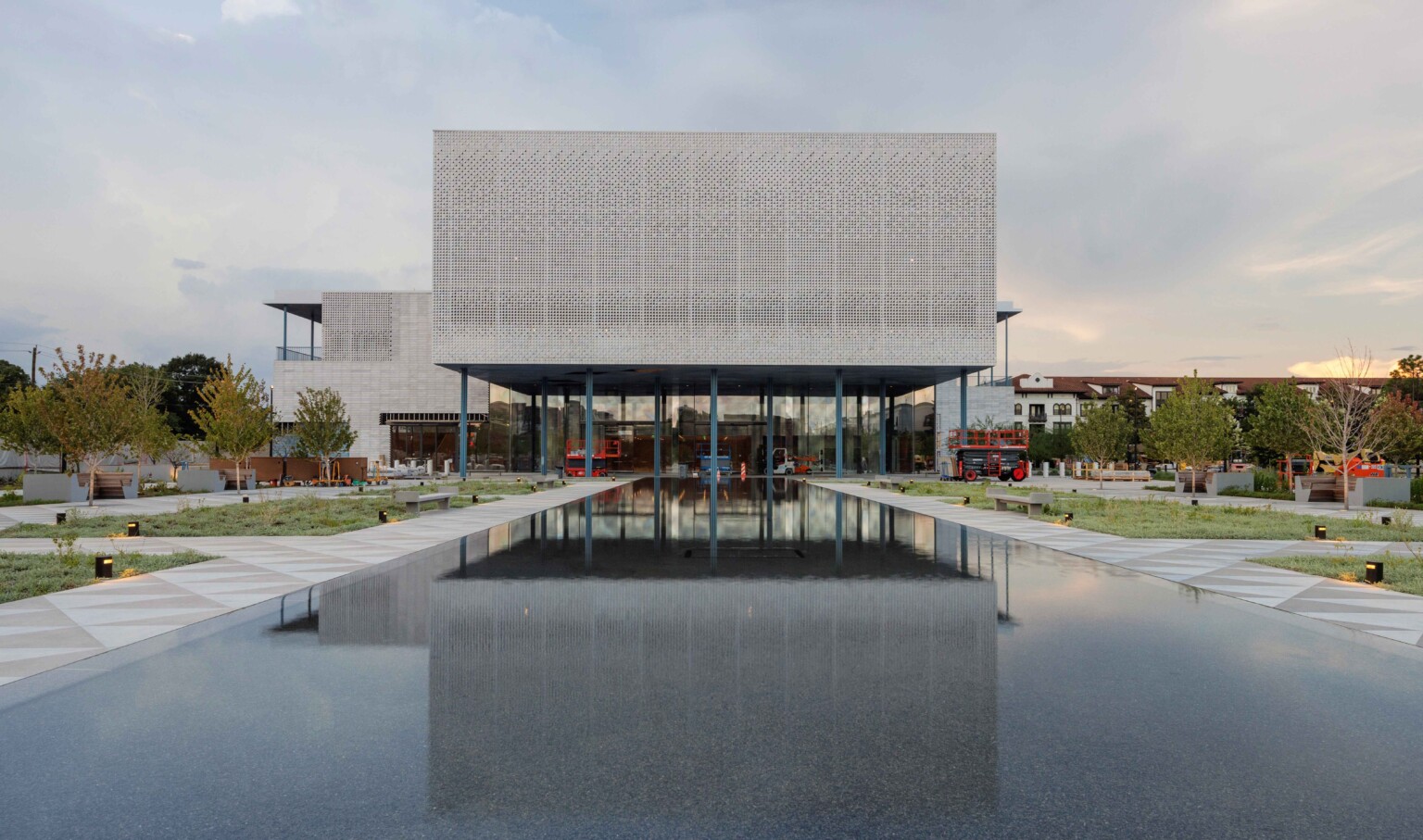 The south elevation of the Ismaili Center Houston, its stone-screen façade mirrored in the reflecting fountain.
