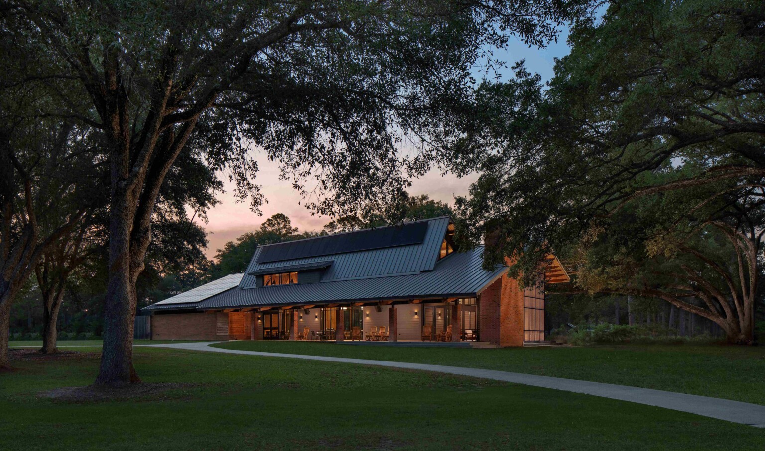 dusk view of the Jones Center Ichauway; angular building designed with surrounding nature, angled roof has solar array for clean energy