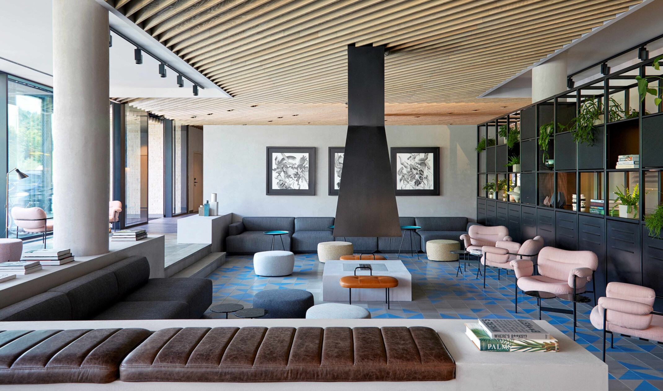 Sunken community space with varied sofa and chair seating around a free floating centered, modern fireplace