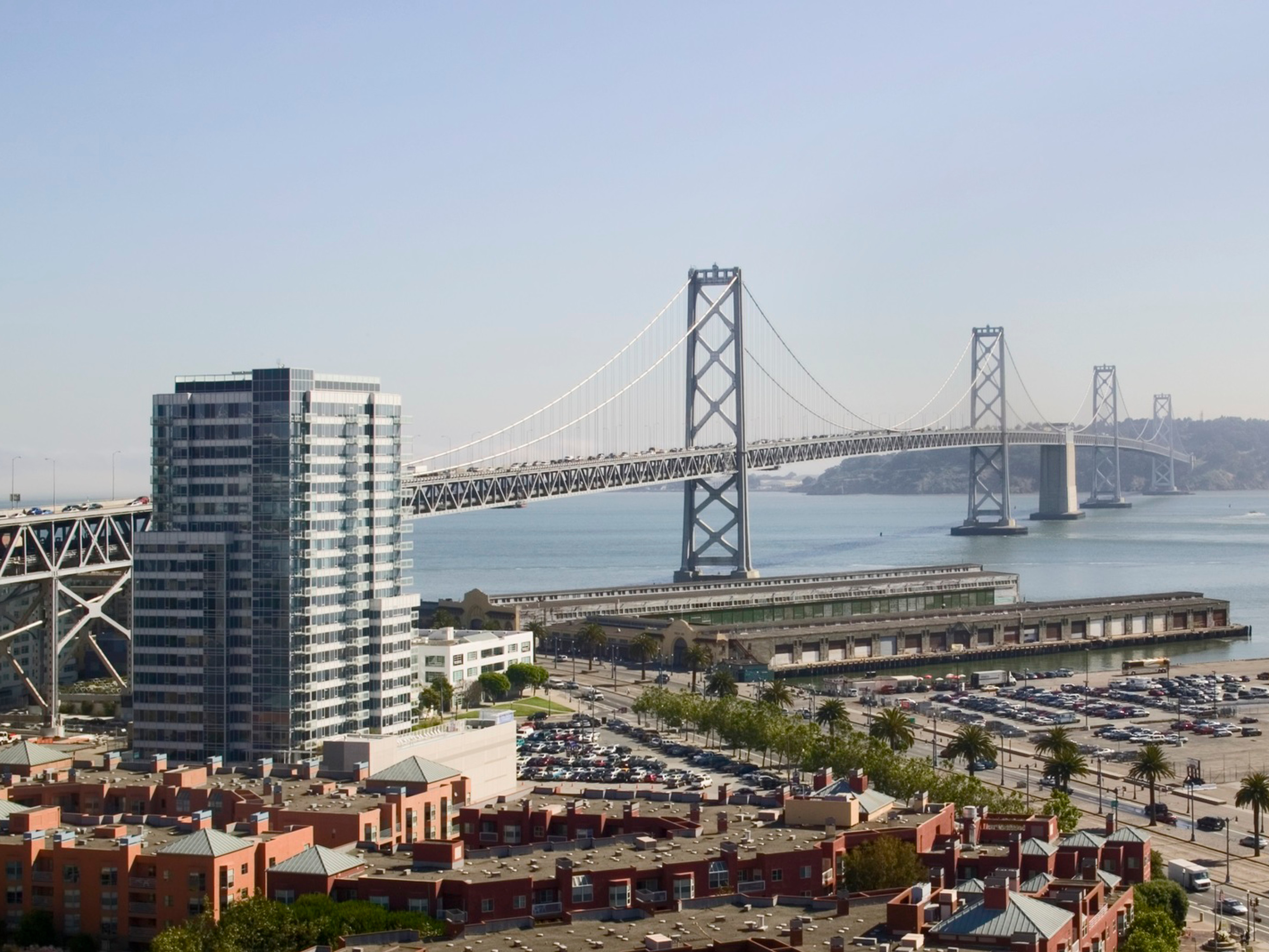 tall stand alone building in front of the bay bridge in San Francisco
