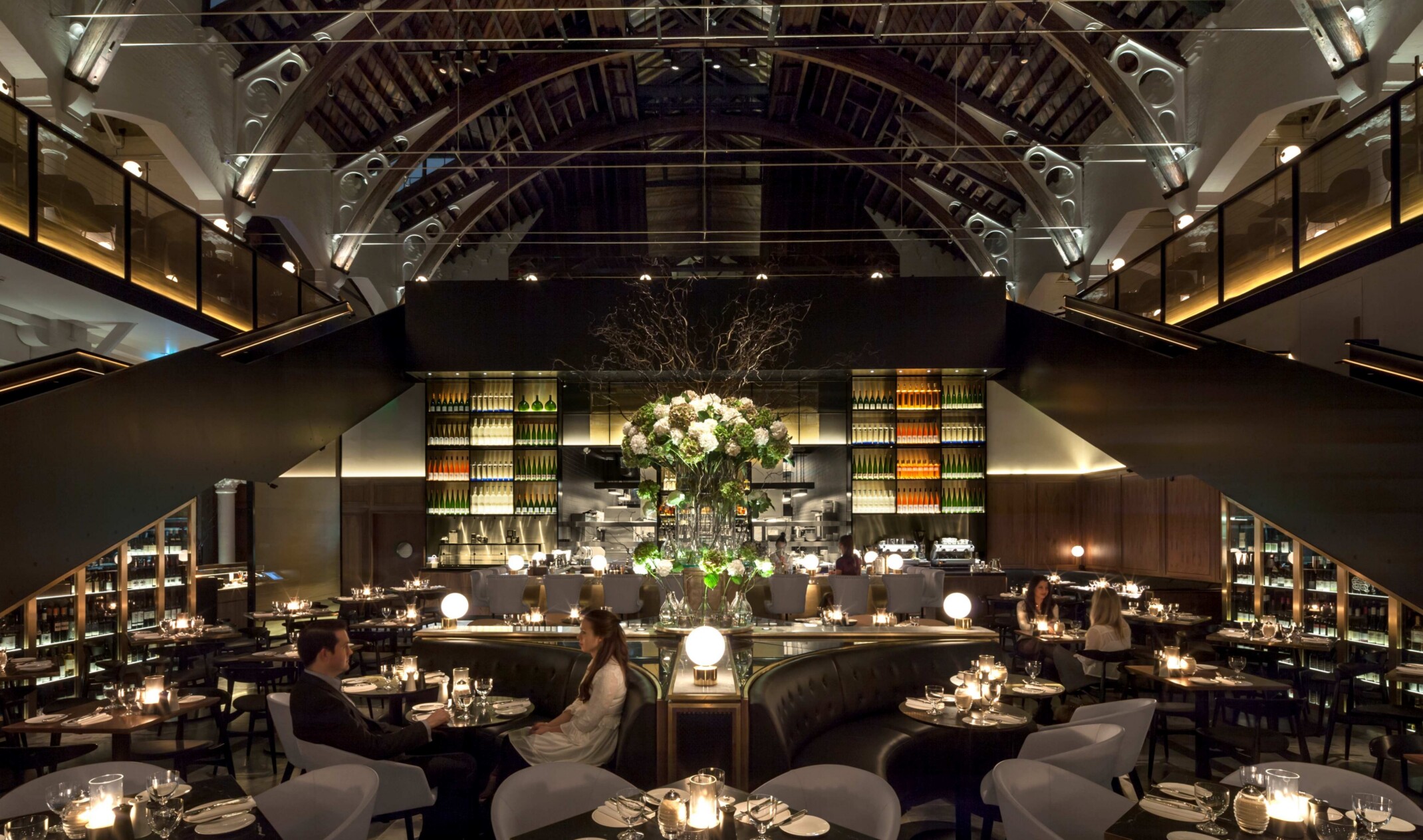double height dining room with exposed architectural ceiling structures and a lower floor fine dining space