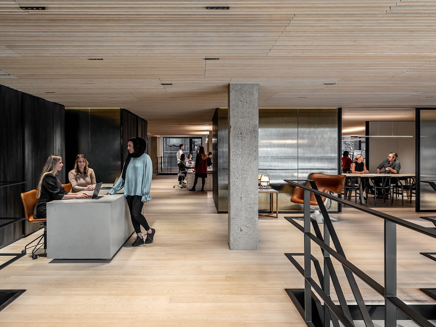 modern office space; varied working stations with sofa and counter seating; background work stations and conference rooms