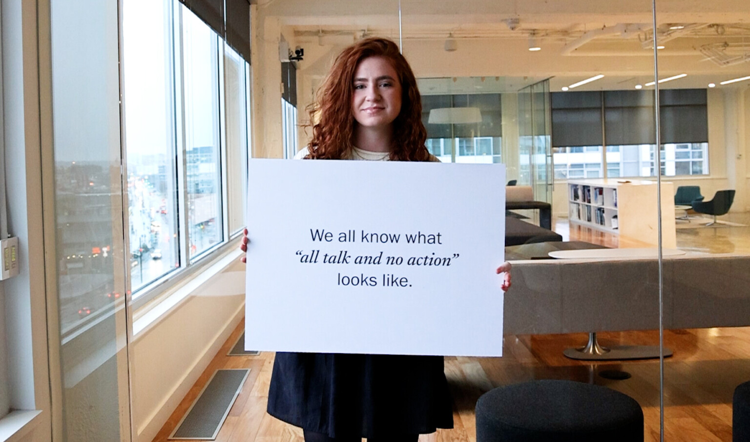 woman standing with a statement on actions companies are taking to tackle climate change woman standing with a statement on actions companies are taking to tackle climate change