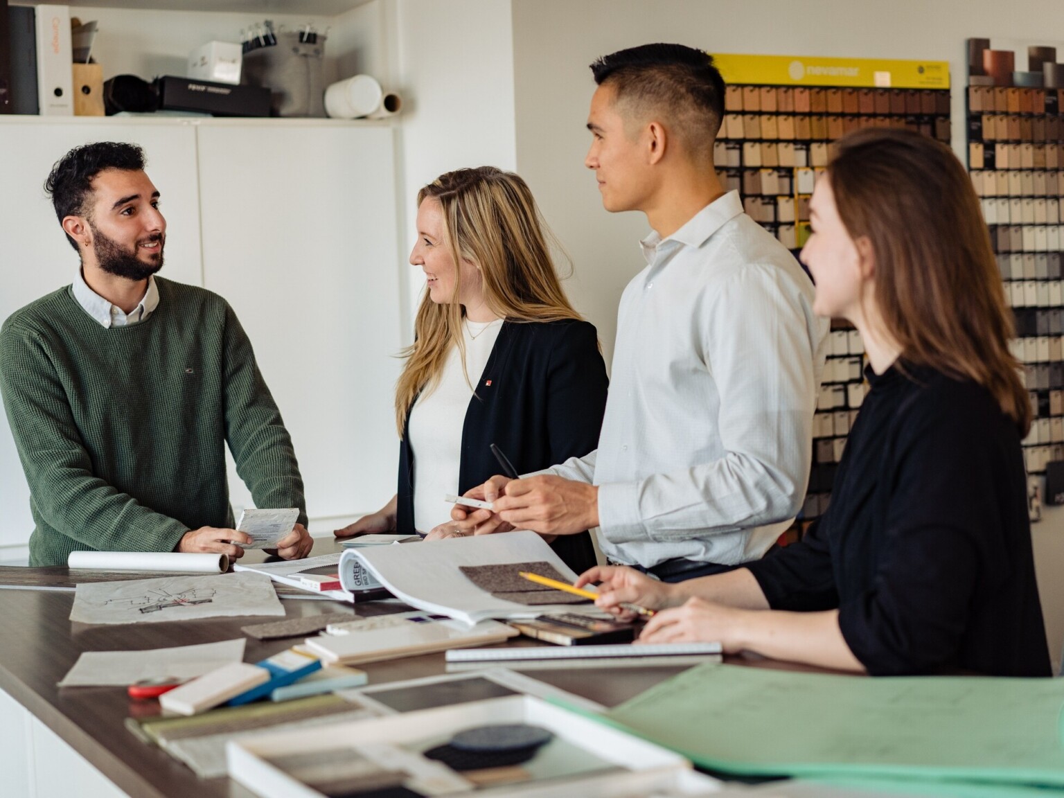designers working together at a table with samples and materials spread