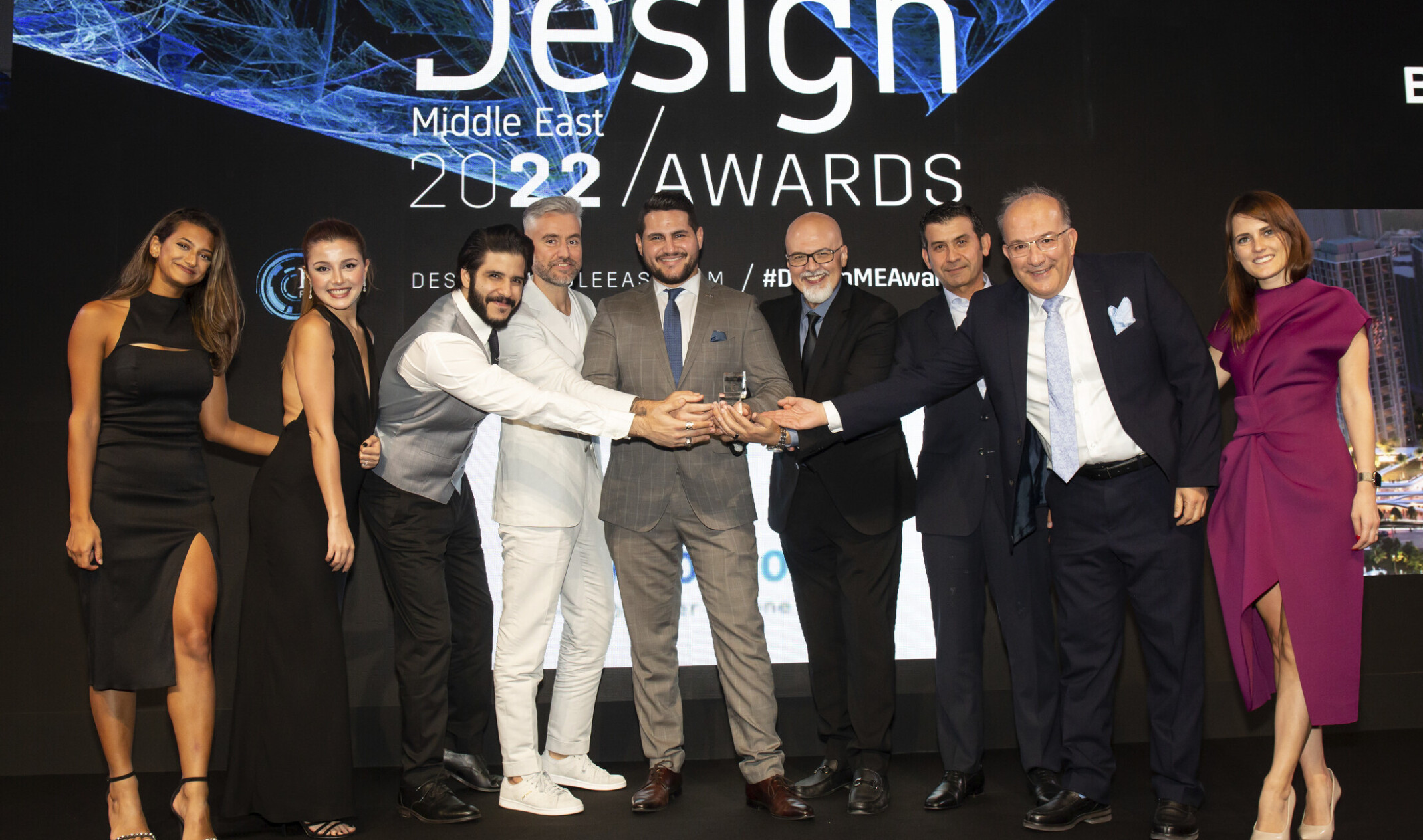 Team members at the Design Middle East award ceremony 2022 with trophy for Interior Design Firm of the Year