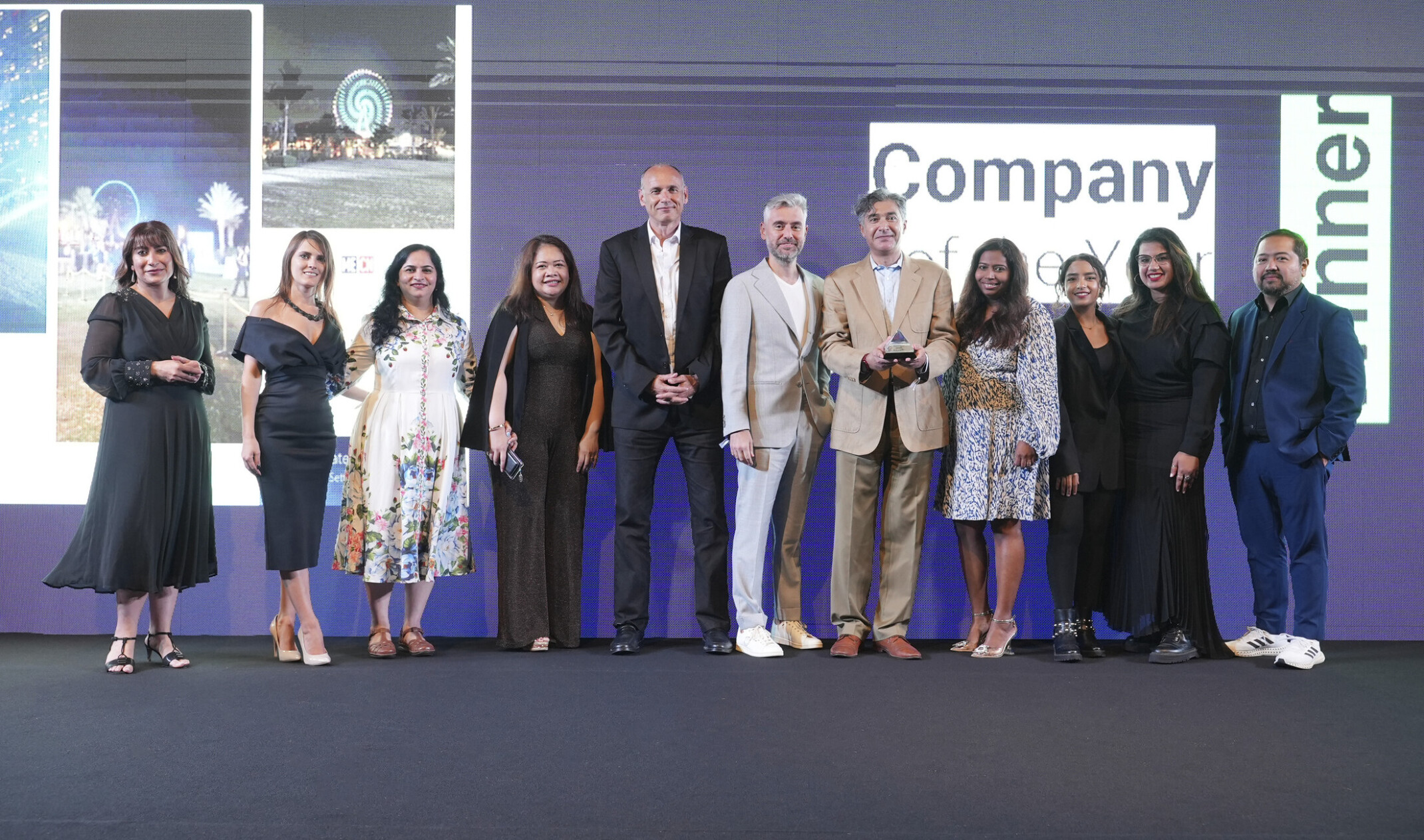 DLR Group's design team in Dubai standing next to each other after receiving the award for 2022 Company of the Year