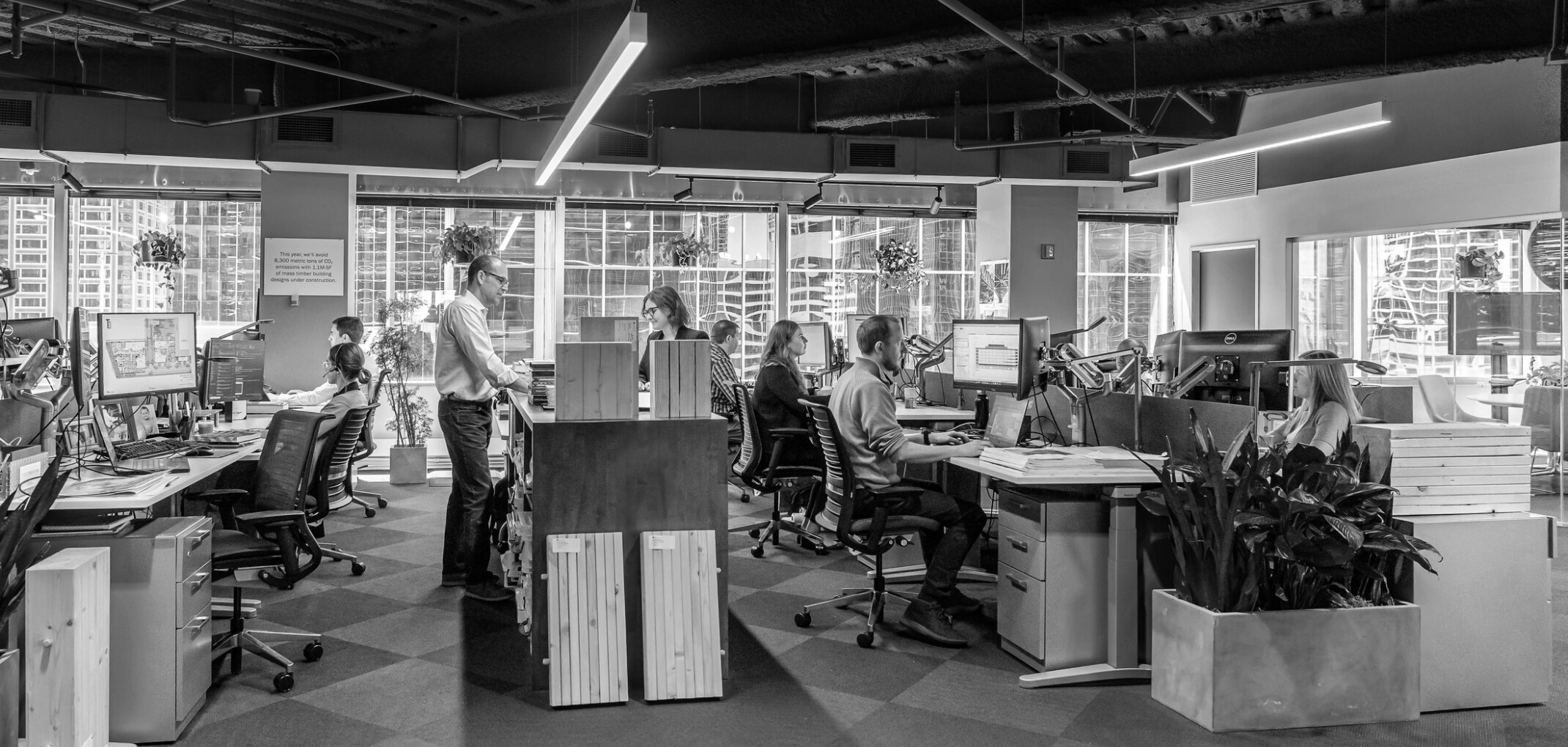 Open concept office space with multiple working spaces on large desks
