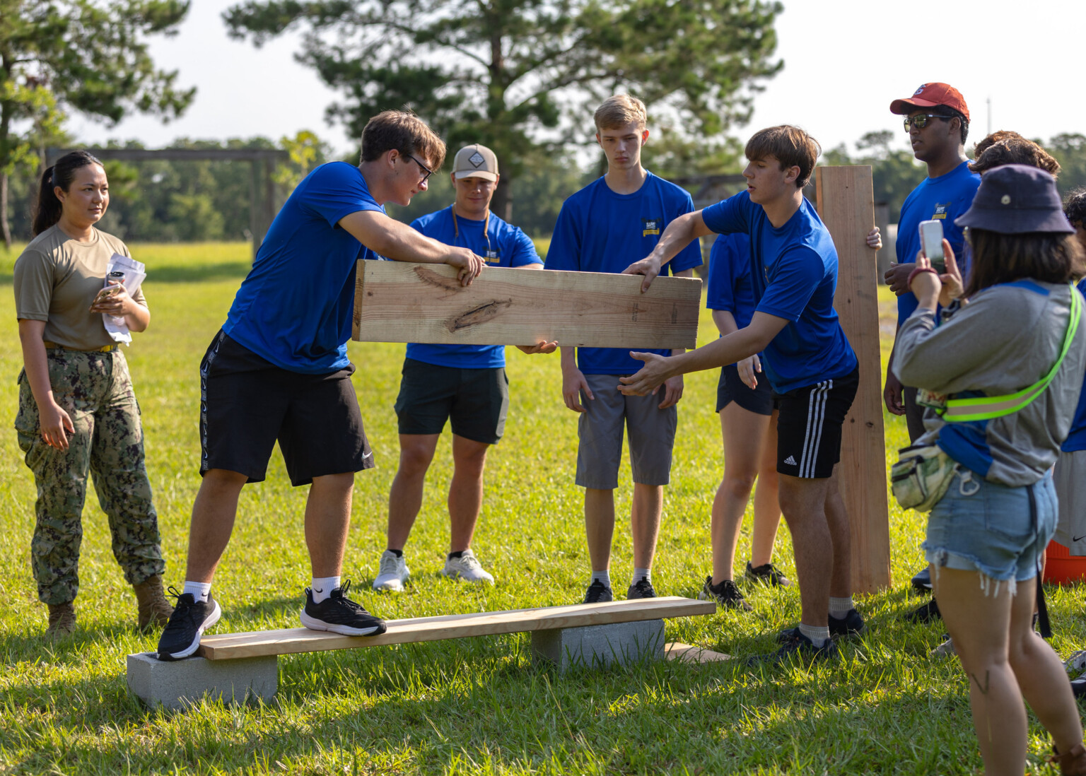 A cadet consults with a high school STEM camper on a construction project at Naval Air Station Jacksonville.