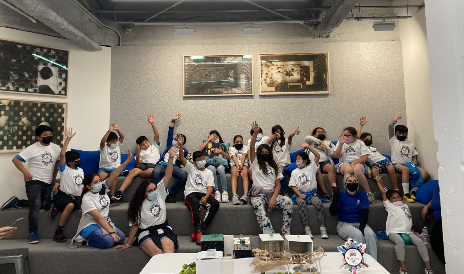 Group of students raising their hands for joy, seated at a learning stair Group of students raising their hands for joy, seated at a learning stair