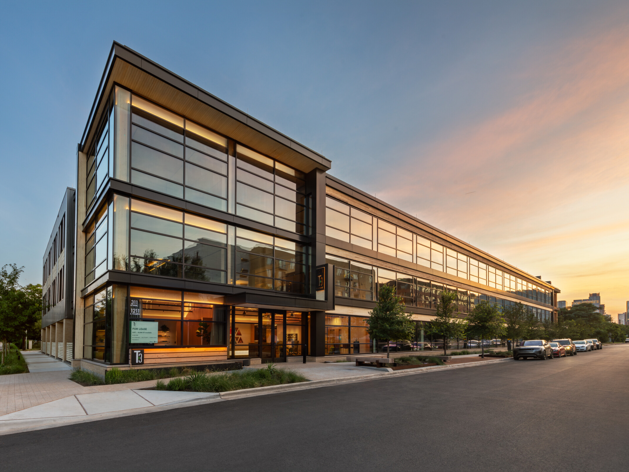 Mass timber midrise building with exposed wood, dark steel and reflective windows