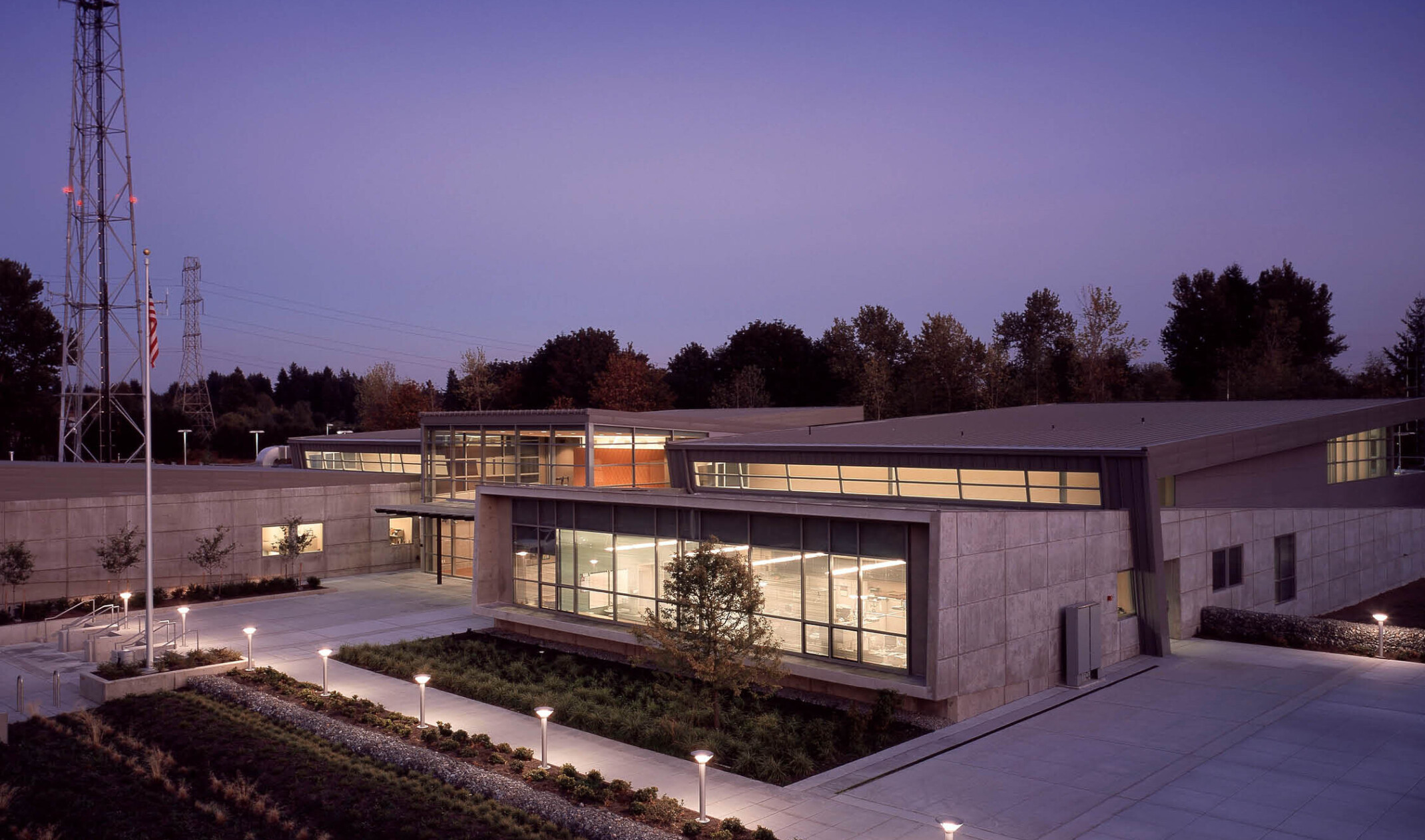 evening view of a communications and emergency center in Washington. Brutalism concrete façade is juxtaposed with modern glass walls.
