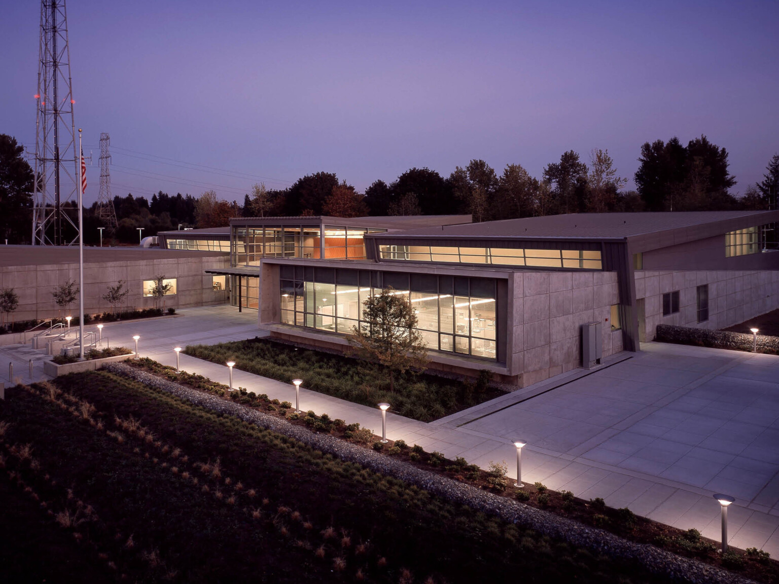 evening view of a communications and emergency center in Washington. Brutalism concrete façade is juxtaposed with modern glass walls.