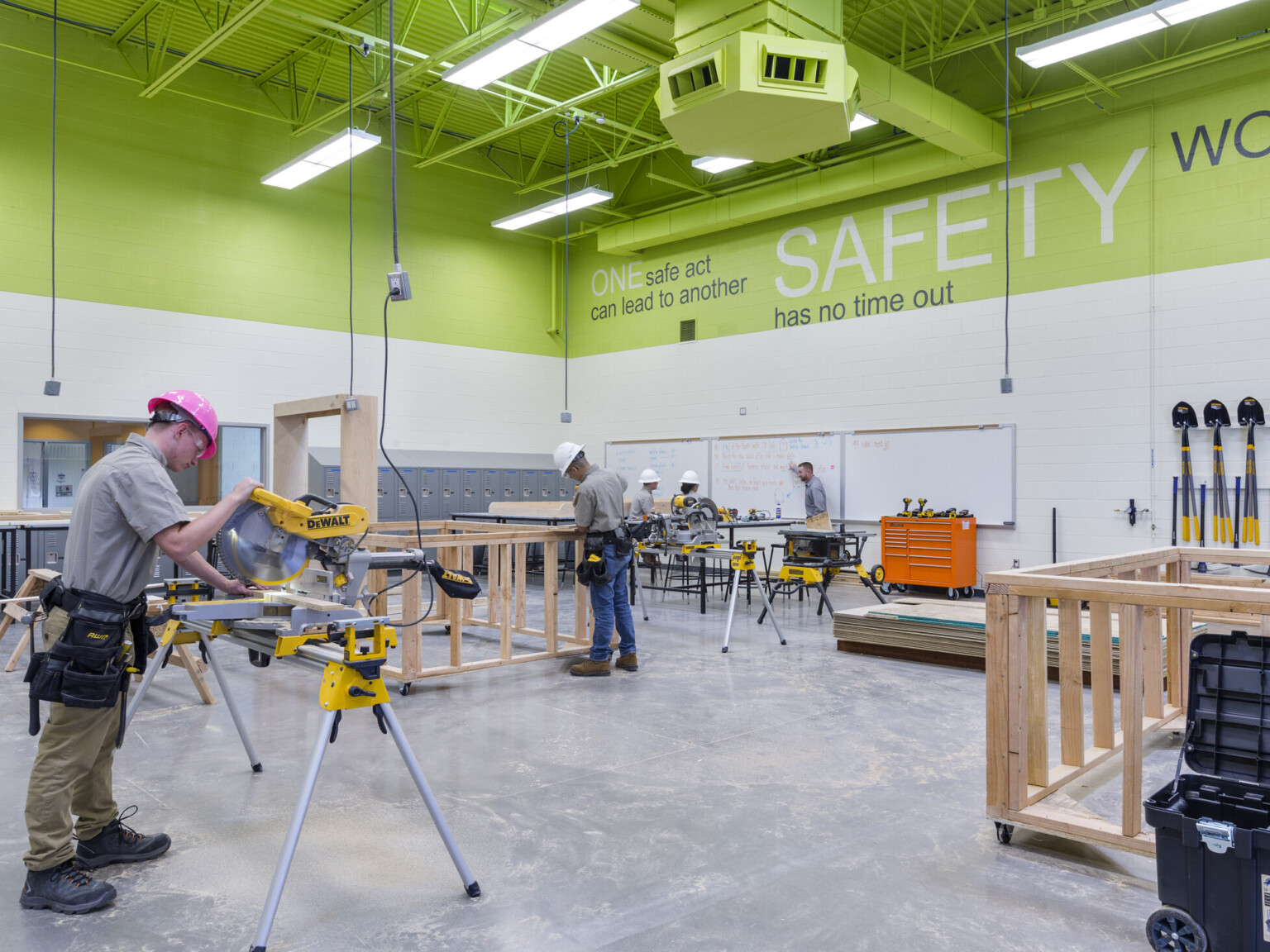 A workshop classroom with students using construction equipment to build wooden frames