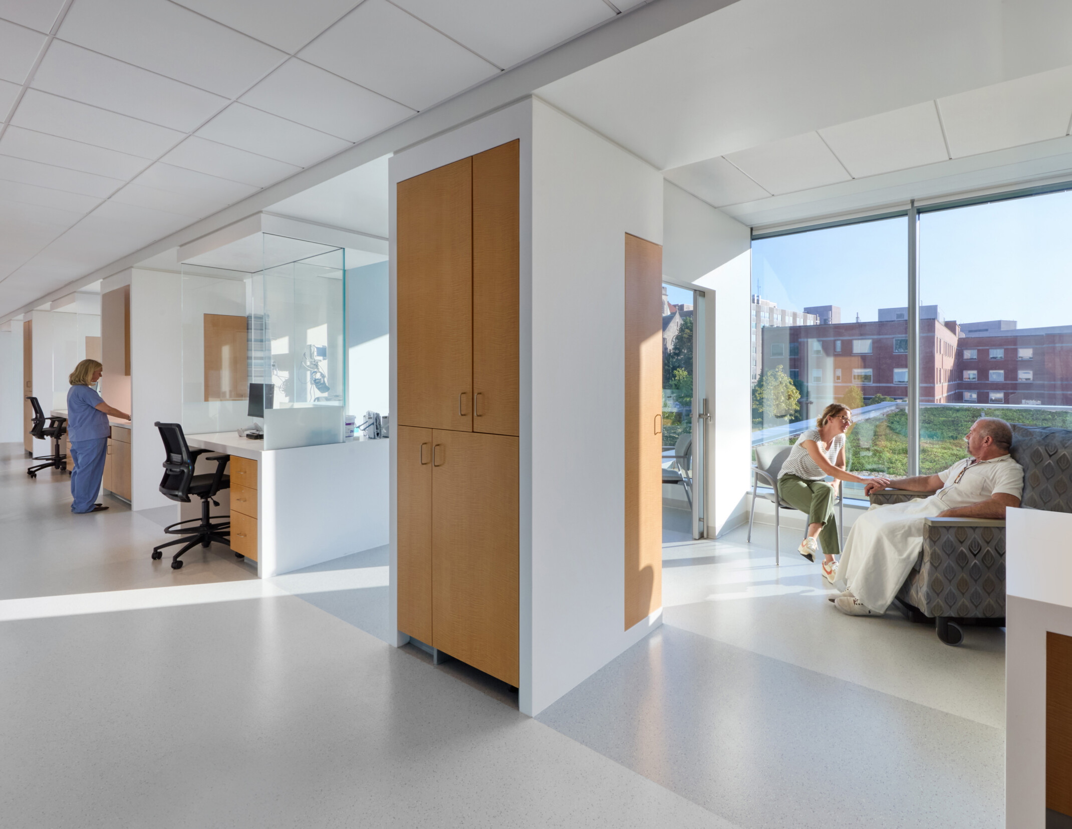 cancer care patient area with daylight streaming in, private rooms, and light colors