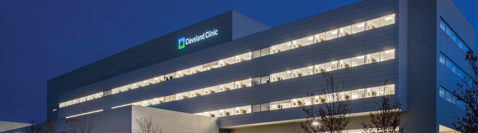 Cleveland Clinic Avon Inpatient Bed Tower illuminated at night seen from across the street facing drive up glass doors