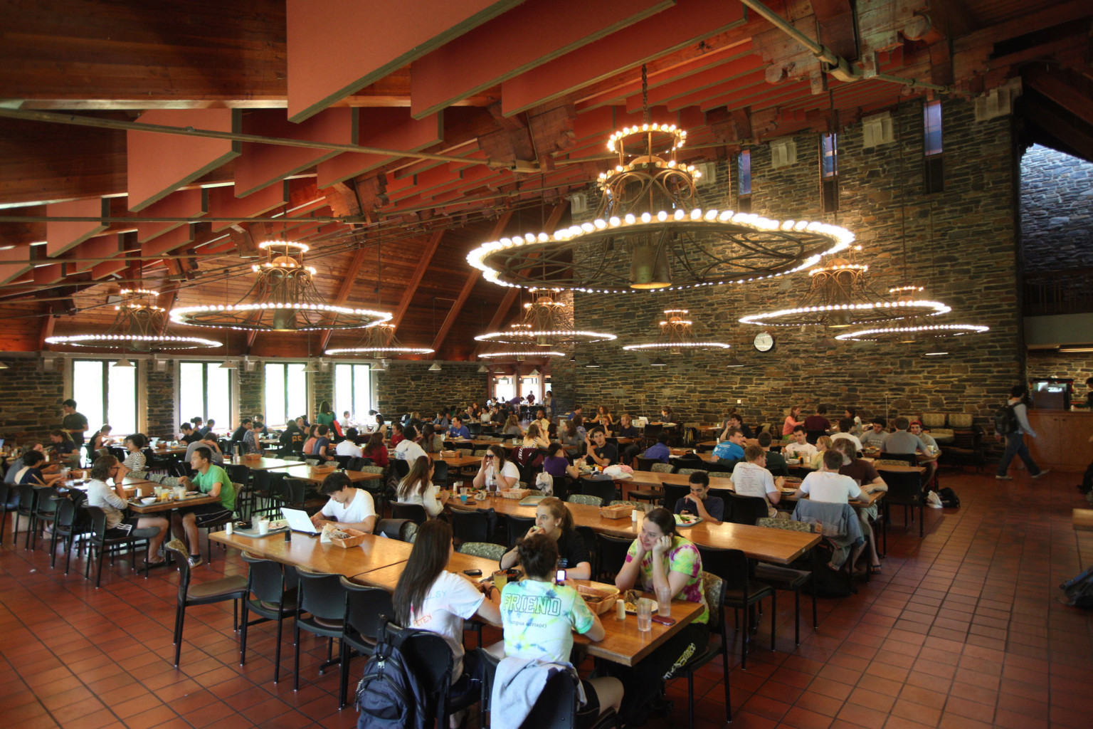 Sharples Dining Hall at Swarthmore College. Rows of tables under wood ceiling with panel accents and layered chandeliers Sharples Dining Hall at Swarthmore College. Rows of tables under wood ceiling with panel accents and layered chandeliers