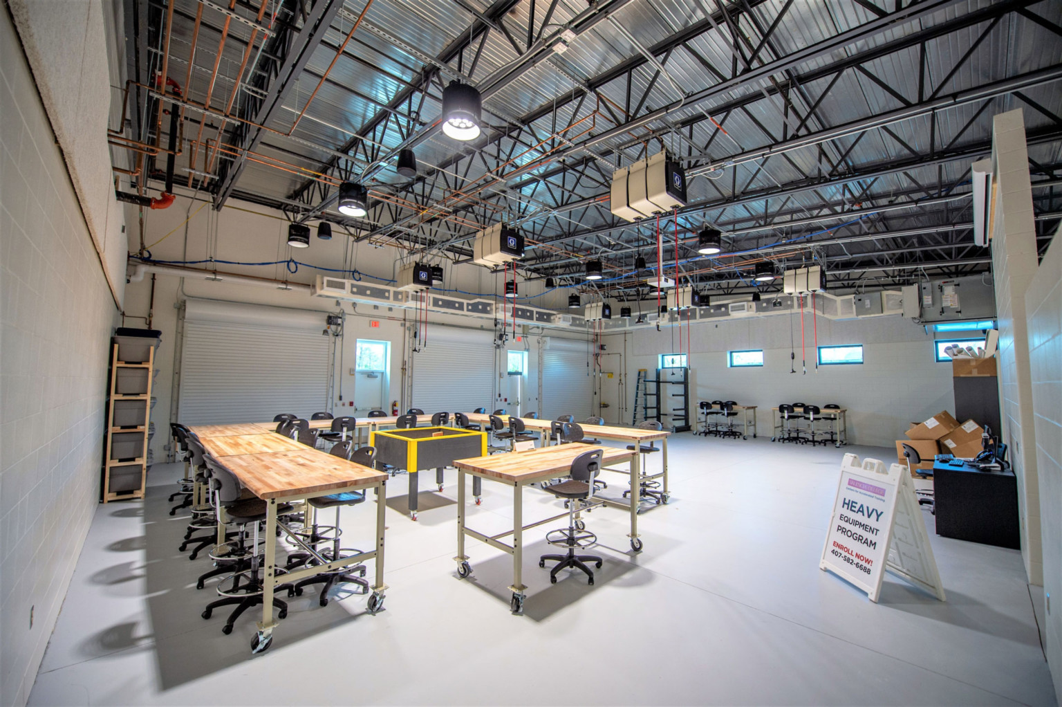 Valencia College Center for Advanced Training Facility, a double height room with exposed structural beams and work benches
