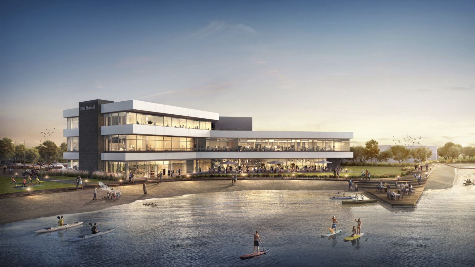 RTG Medical Headquarters viewed from across the water. A 3 story building with large windows and waterfront patio and dock