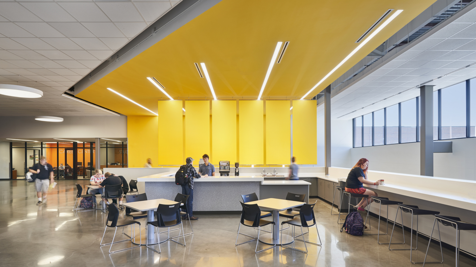 21st century learning environment activating community space for students with study counter and yellow design feature covering the wall and ceiling at salina south high school