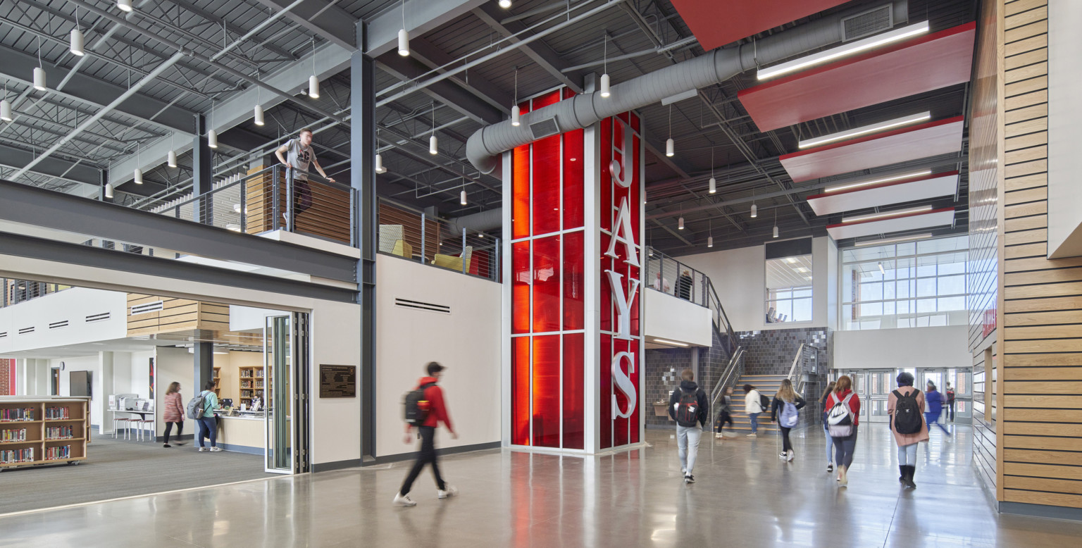 Jefferson City High School interior double height atrium with red translucent column reading Jays down the right side