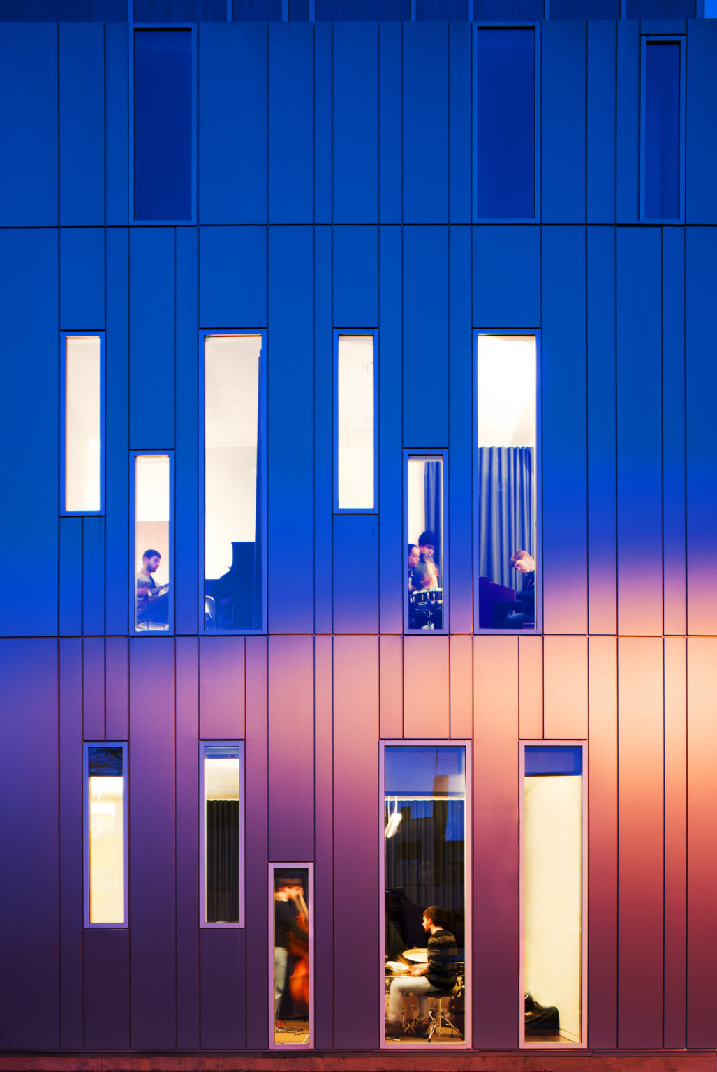 Wall with vertical stripes looking and long, thin rectangular windows of differing size and alignment with view of musicians Wall with vertical stripes looking and long, thin rectangular windows of differing size and alignment with view of musicians