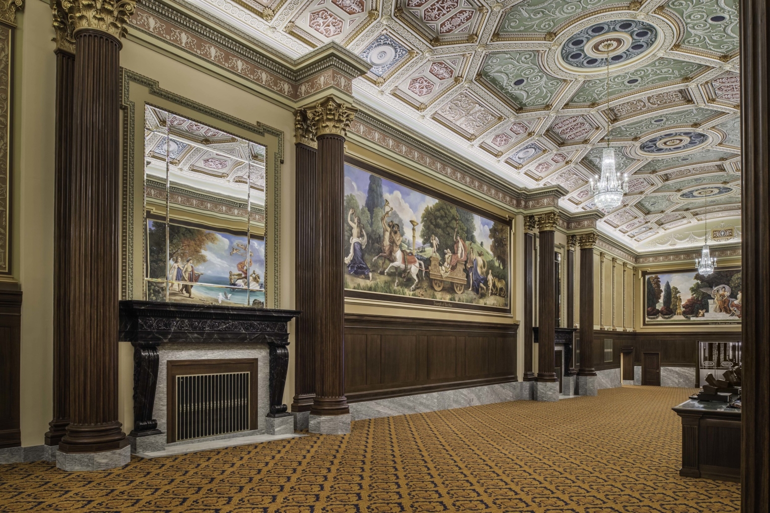a carpeted hallway with corinthian columns and colorful ceiling frescoes in the ohio theater lobby a carpeted hallway with corinthian columns and colorful ceiling frescoes in the ohio theater lobby