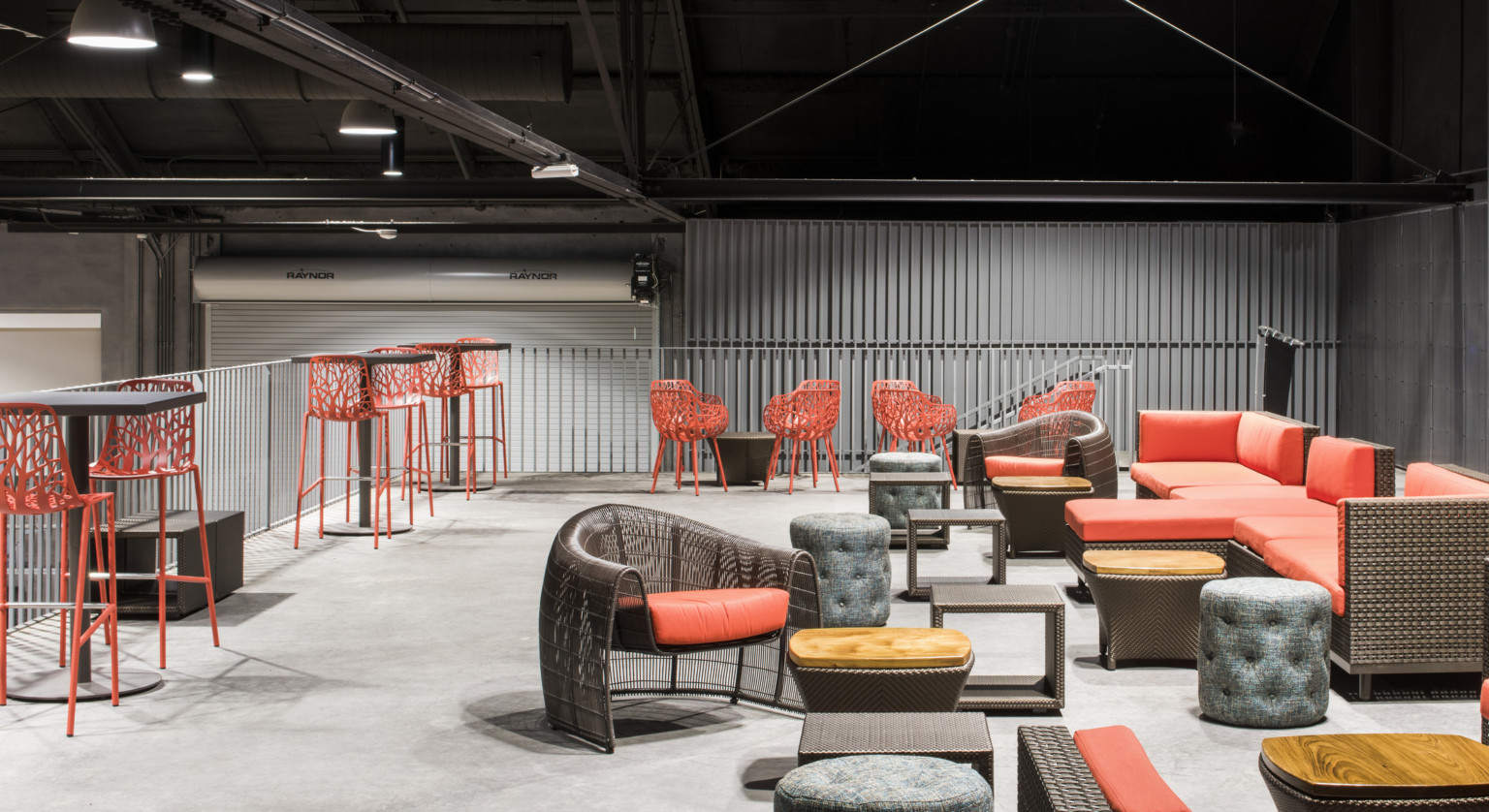 Red lounge seating on mezzanine with couches, chairs, stools, and tables