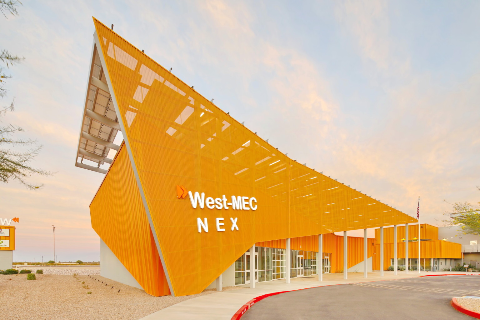 West-MEC NEX building at the Southwest Campus, an angular yellow building with sunscreen across the front with white sign West-MEC NEX building at the Southwest Campus, an angular yellow building with sunscreen across the front with white sign