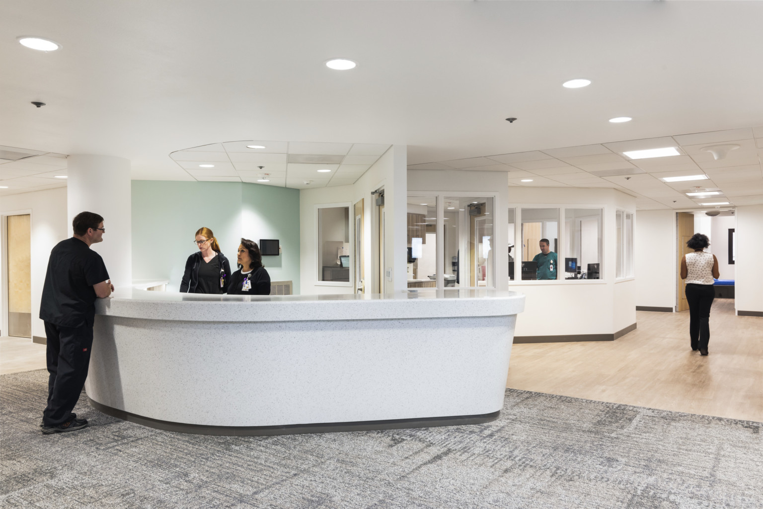 Valleywise Behavioral Health Center reception area with grey stone desk in front of hallway with irregularly shaped offices