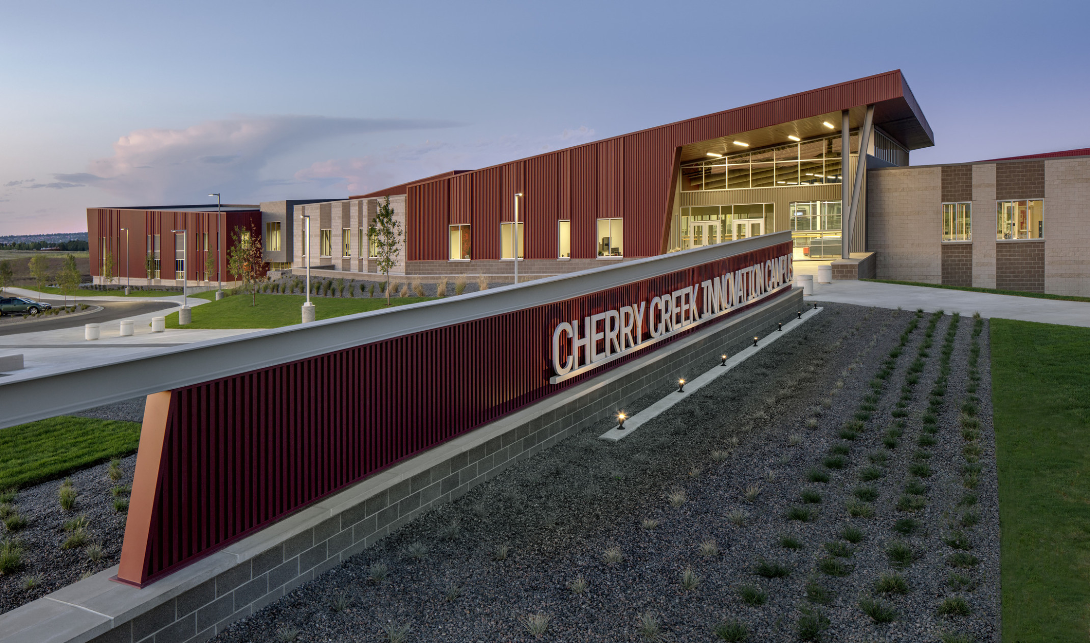 Cherry Creek Career and Innovation Academy Campus entrance, a red panel building with long sign and canopy over glass entry