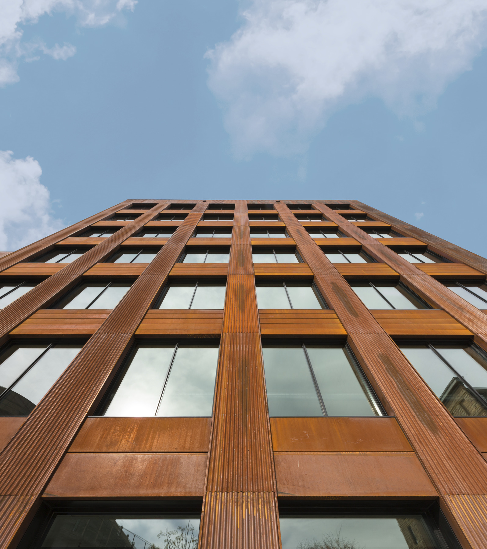 View from base of midrise tower looking upwards. Paneled columns separate square sections of windows View from base of midrise tower looking upwards. Paneled columns separate square sections of windows