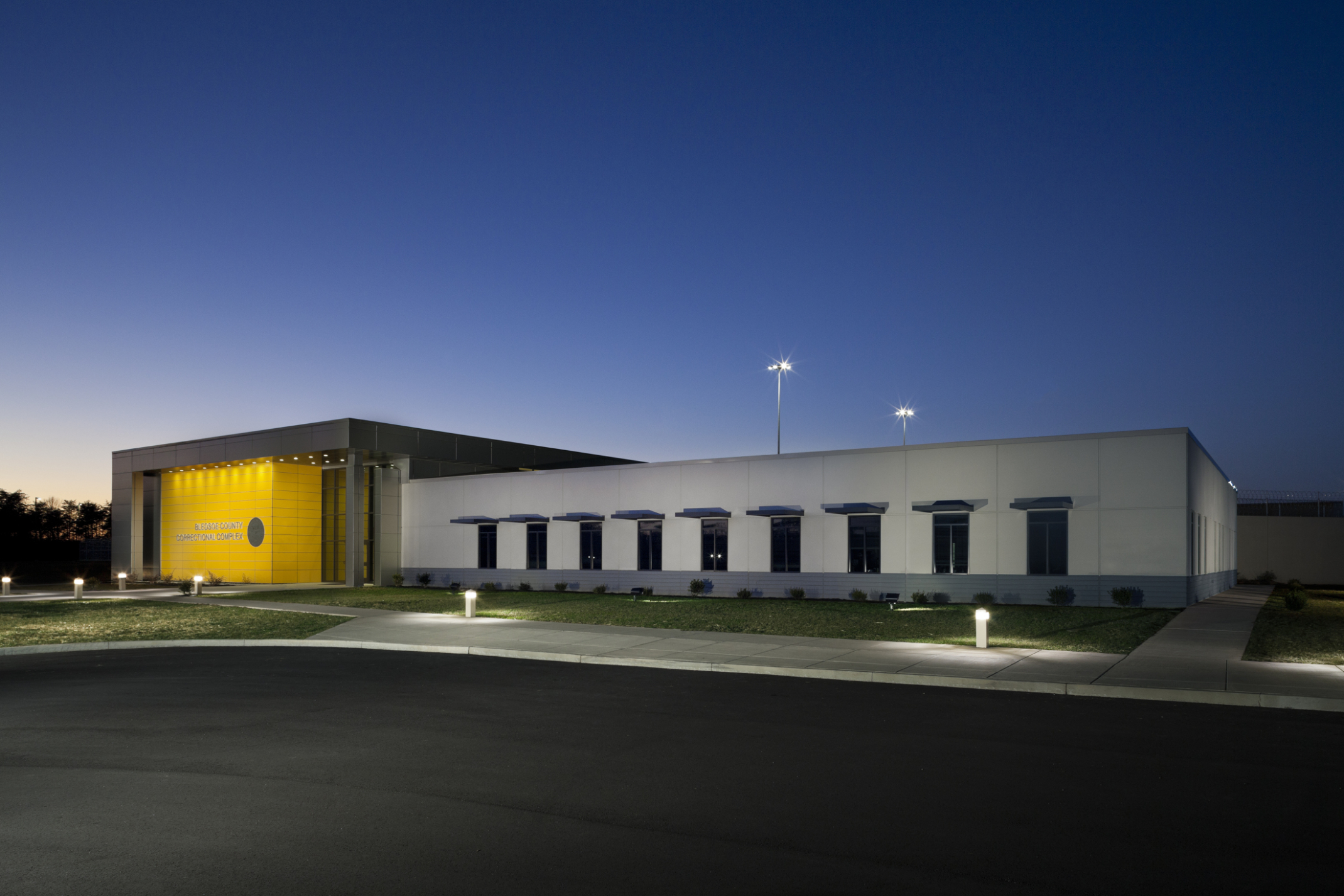 Evening view of the entryway complete with a yellow accent wall and windows into Bledsoe County Correctional Complex.