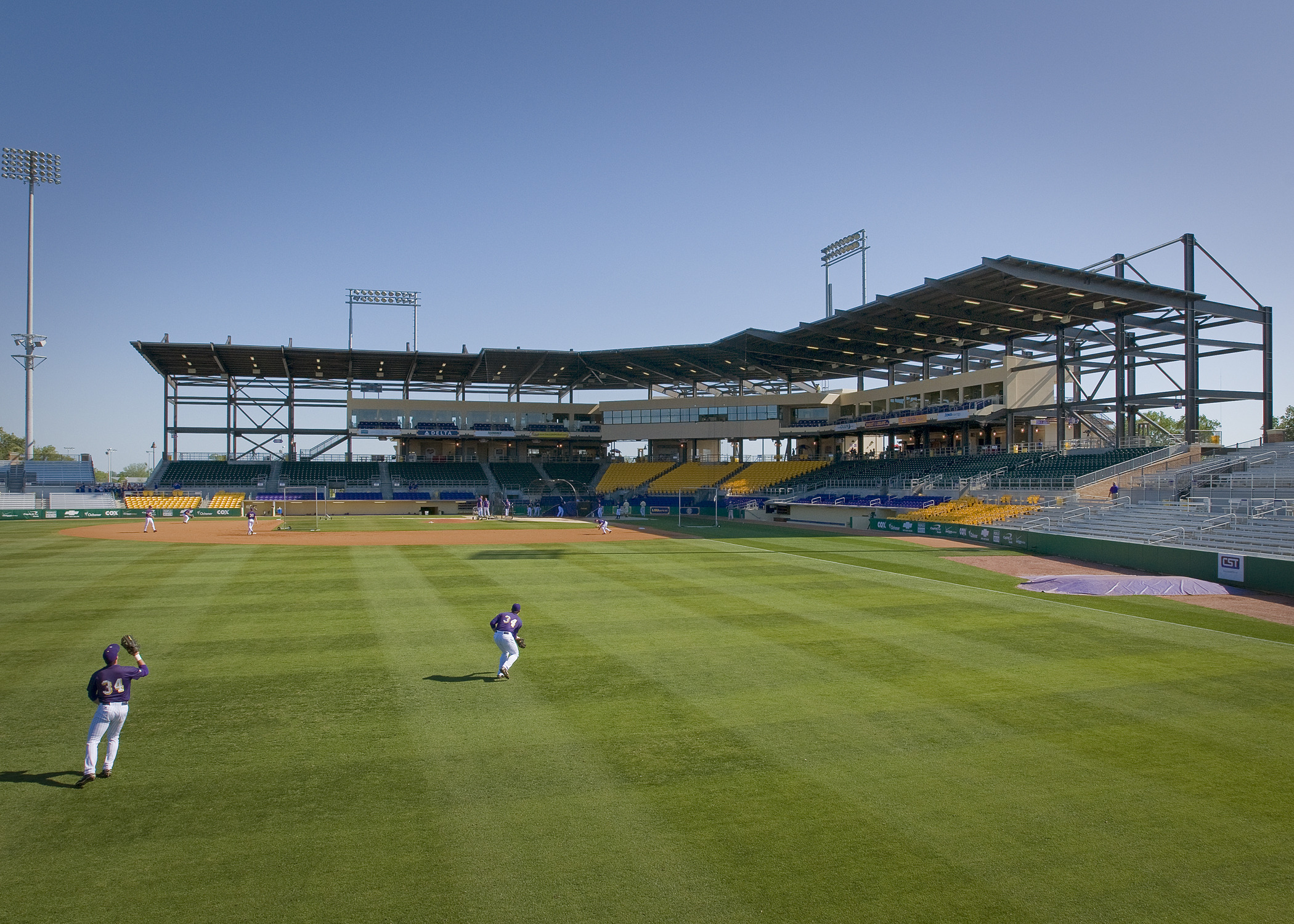 Alex Box Stadium at Louisiana State University viewed from the outfield. Yellow seats around home plate with box suites above
