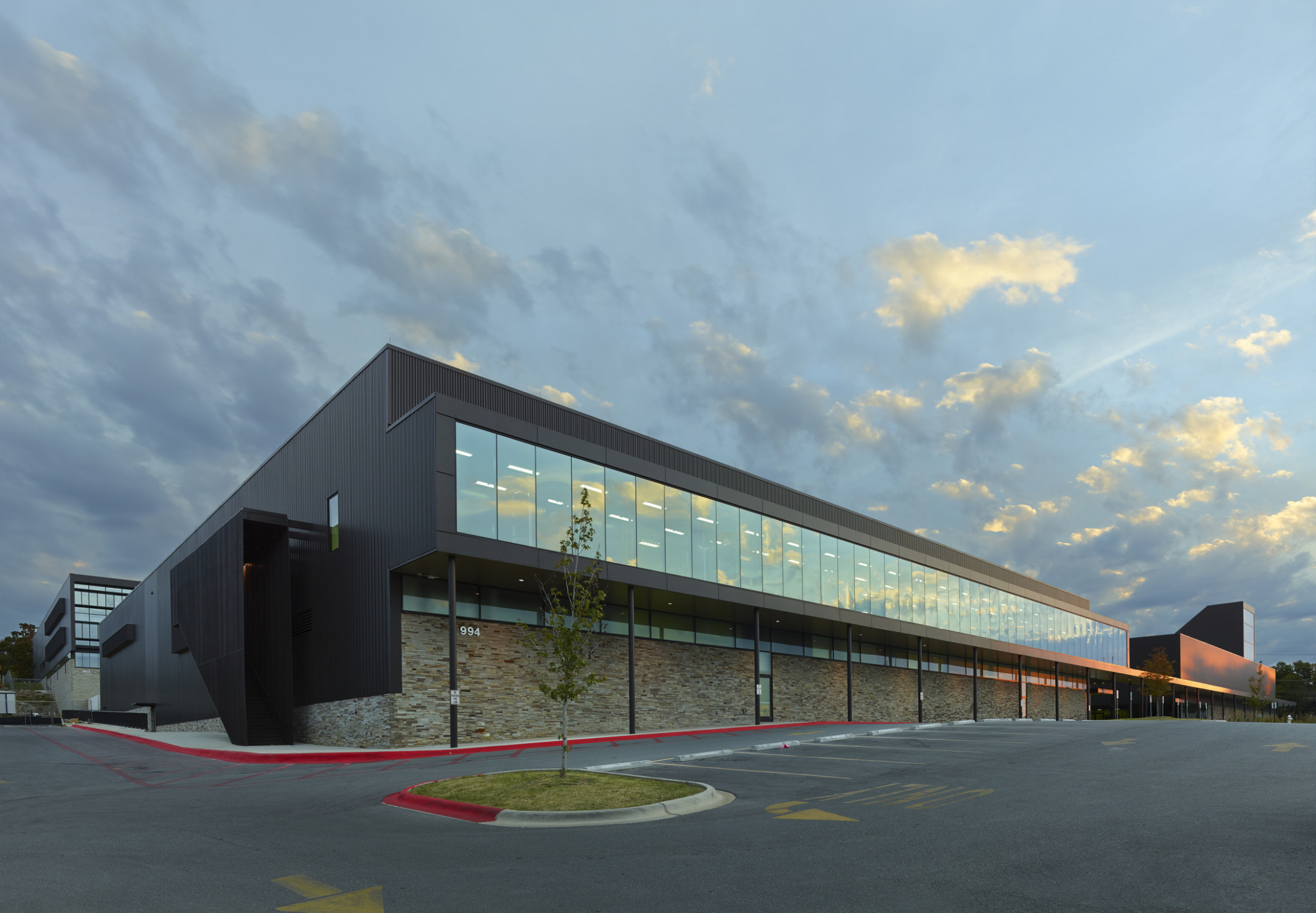 Fayetteville High School 2nd floor with seamless window hallway extends to create covered walkway above stone wall to entry Fayetteville High School 2nd floor with seamless window hallway extends to create covered walkway above stone wall to entry