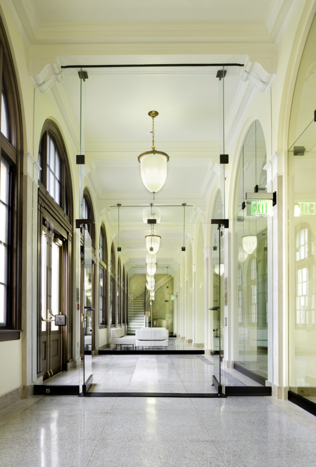 a mirrored hallway flanked by arched windows a mirrored hallway flanked by arched windows
